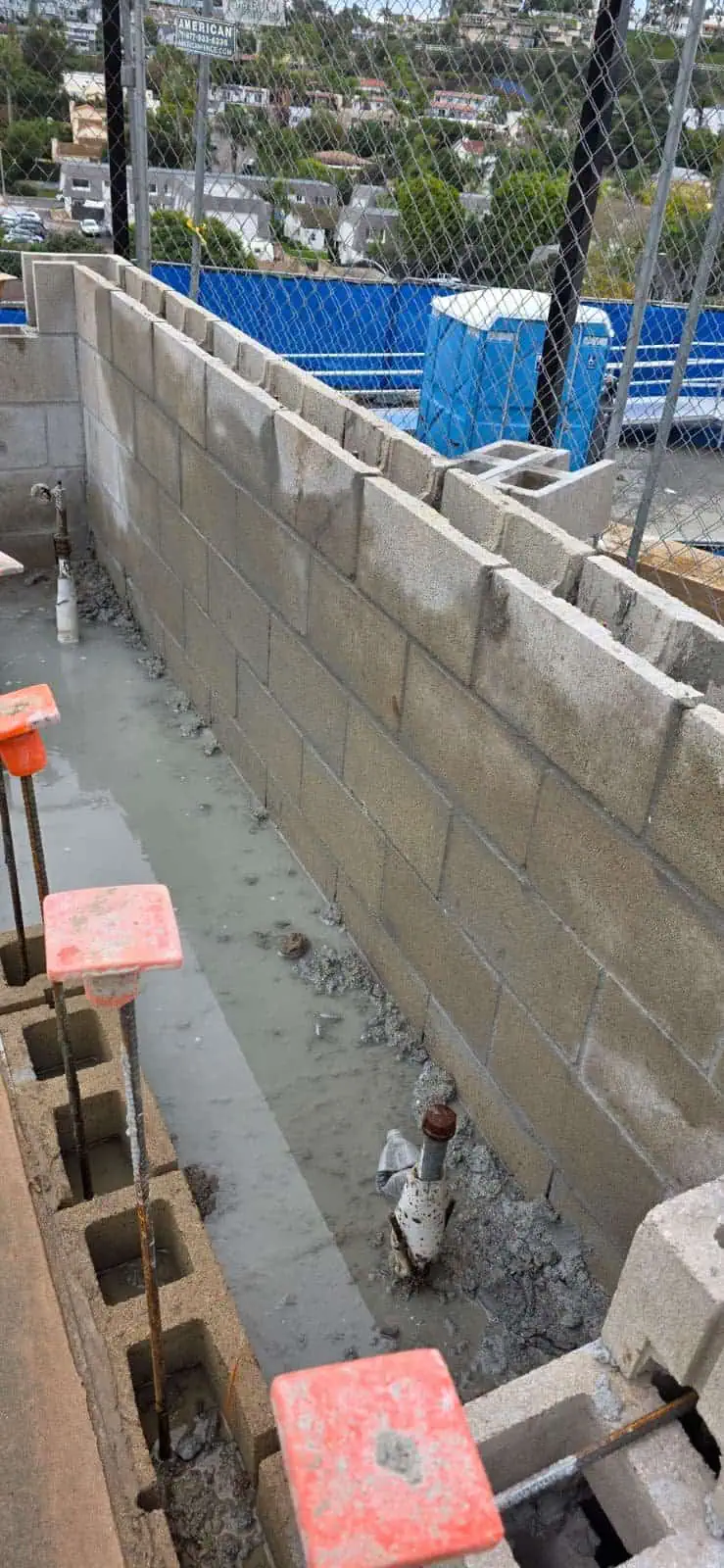 Masonry wall being built with concrete blocks for a commercial project.