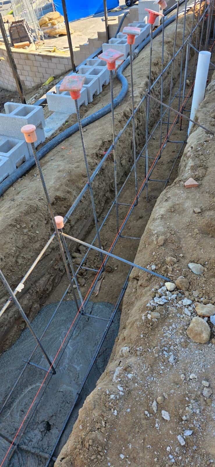 Reinforced concrete foundation with rebar for masonry wall construction.