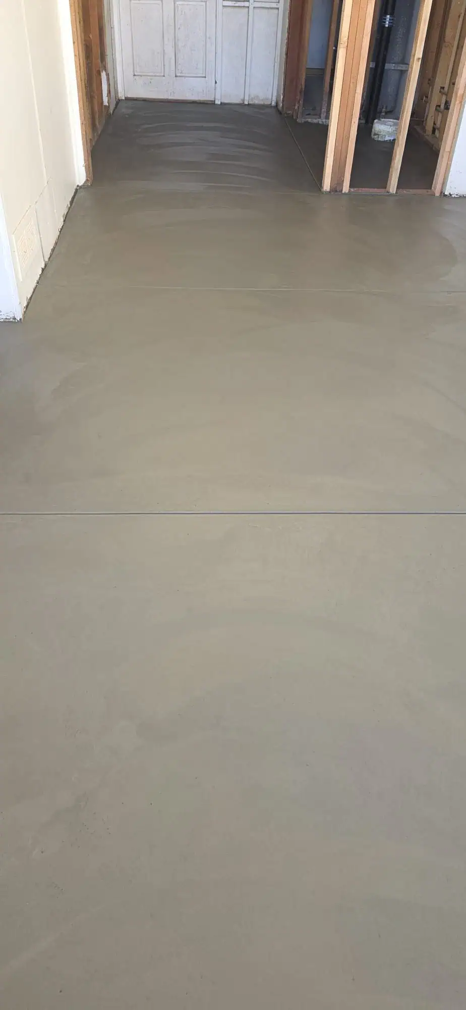 Concrete flooring installation in progress at a construction site.